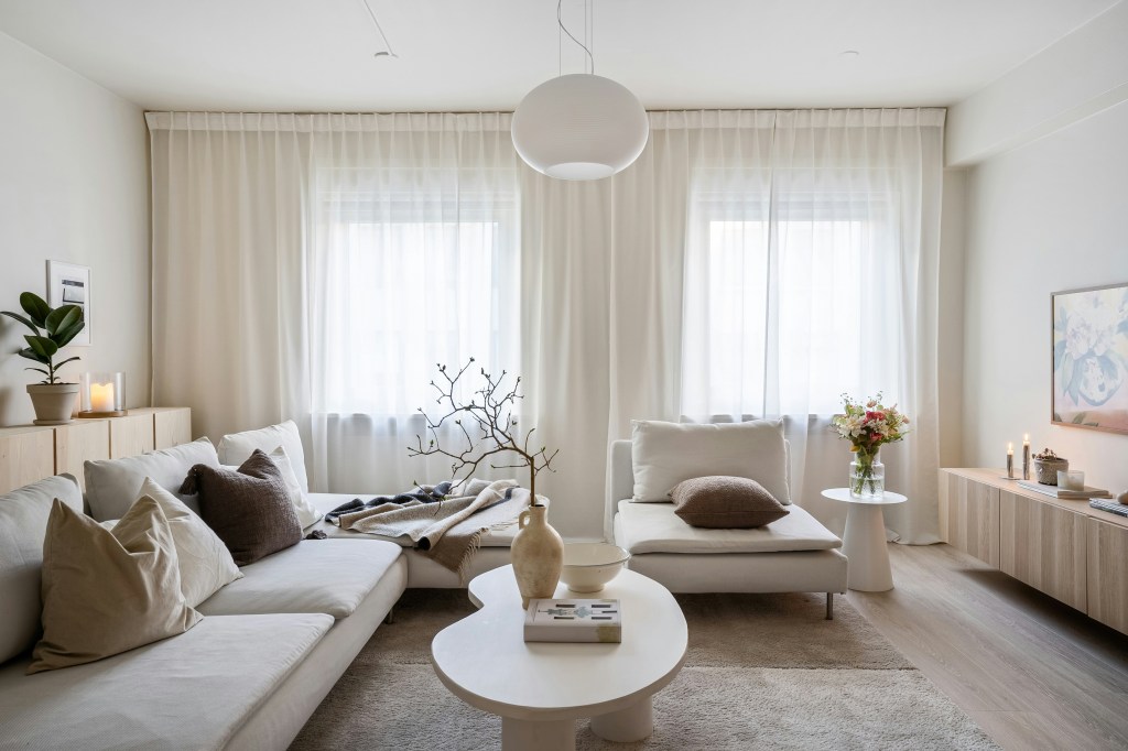 Przytulny salon w stylu skandynawskim z beżowymi ścianami i drewnianymi meblami.