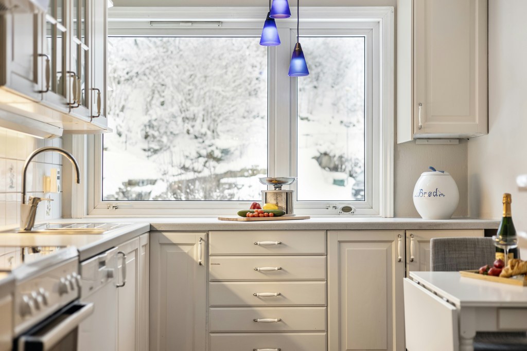 Kuchnia w ciepłej bieli, ponadczasowa baza kolorystyczna, modne wnętrze 2025