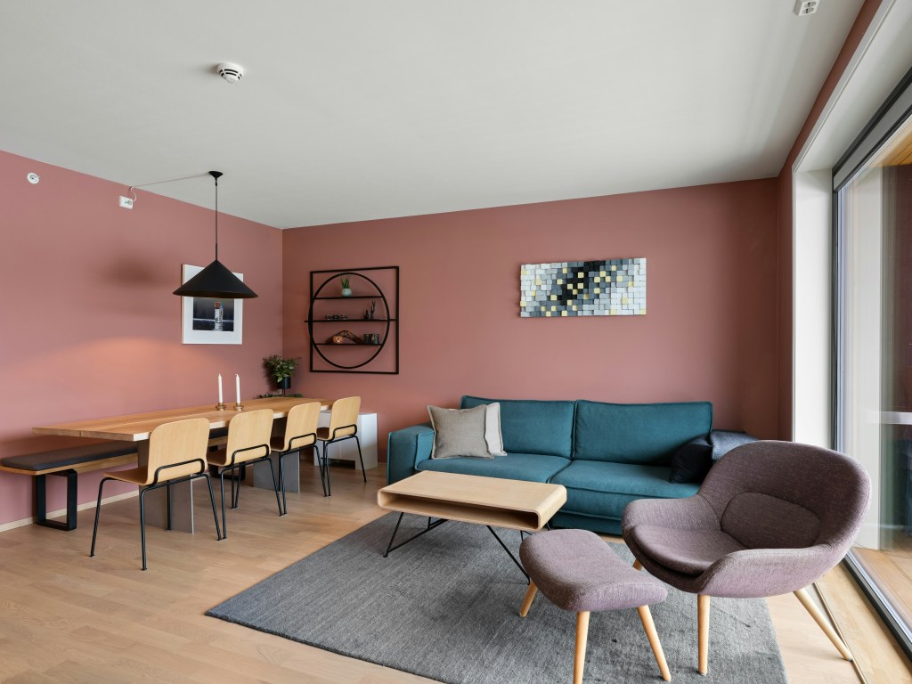 Jasnoróżowy salon w romantycznym stylu z miękkimi tkaninami.