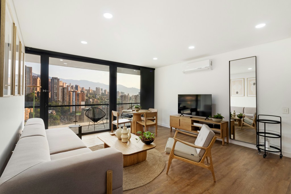 Jasny salon w stylu skandynawskim w małym mieszkaniu z białymi ścianami i drewnianą podłogą