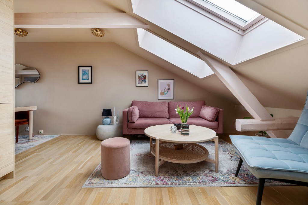 Przytulny salon na poddaszu z różowymi ścianami